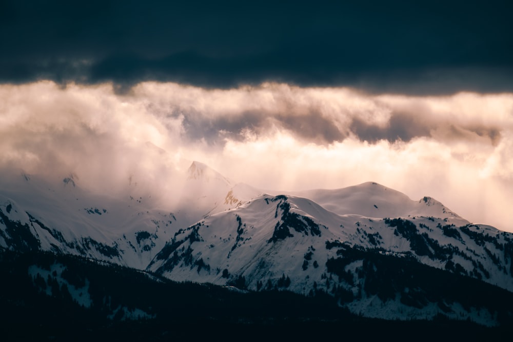 montagne enneigée sous un ciel nuageux pendant la journée