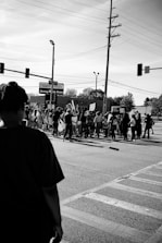 Activists holding bullhorns and campaign signs at a busy intersection advocating for consumer justice.