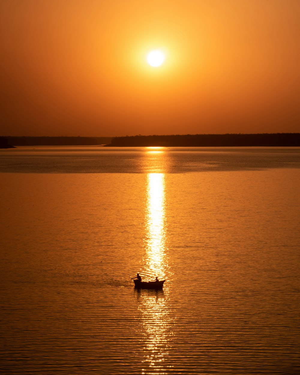 silhouette of person riding on boat on sea during sunset
