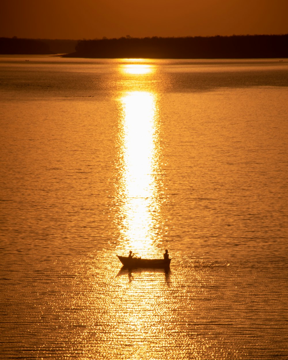 silhouette of person on boat on sea during sunset