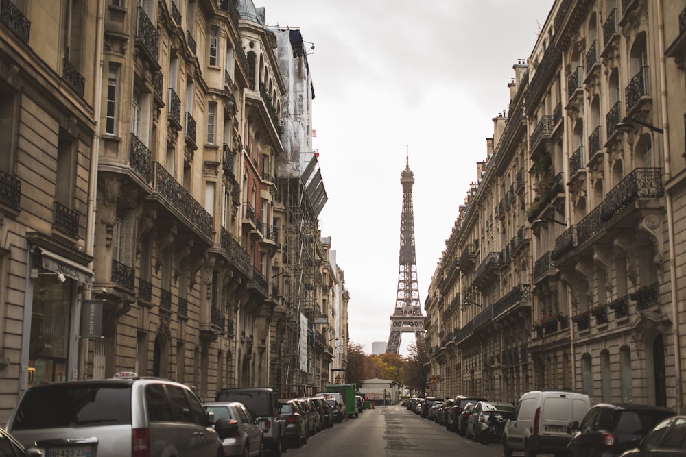 cars parked on street in between high rise buildings during daytime