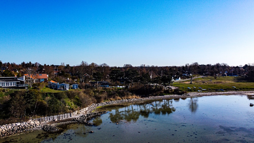 body of water near trees and houses during daytime