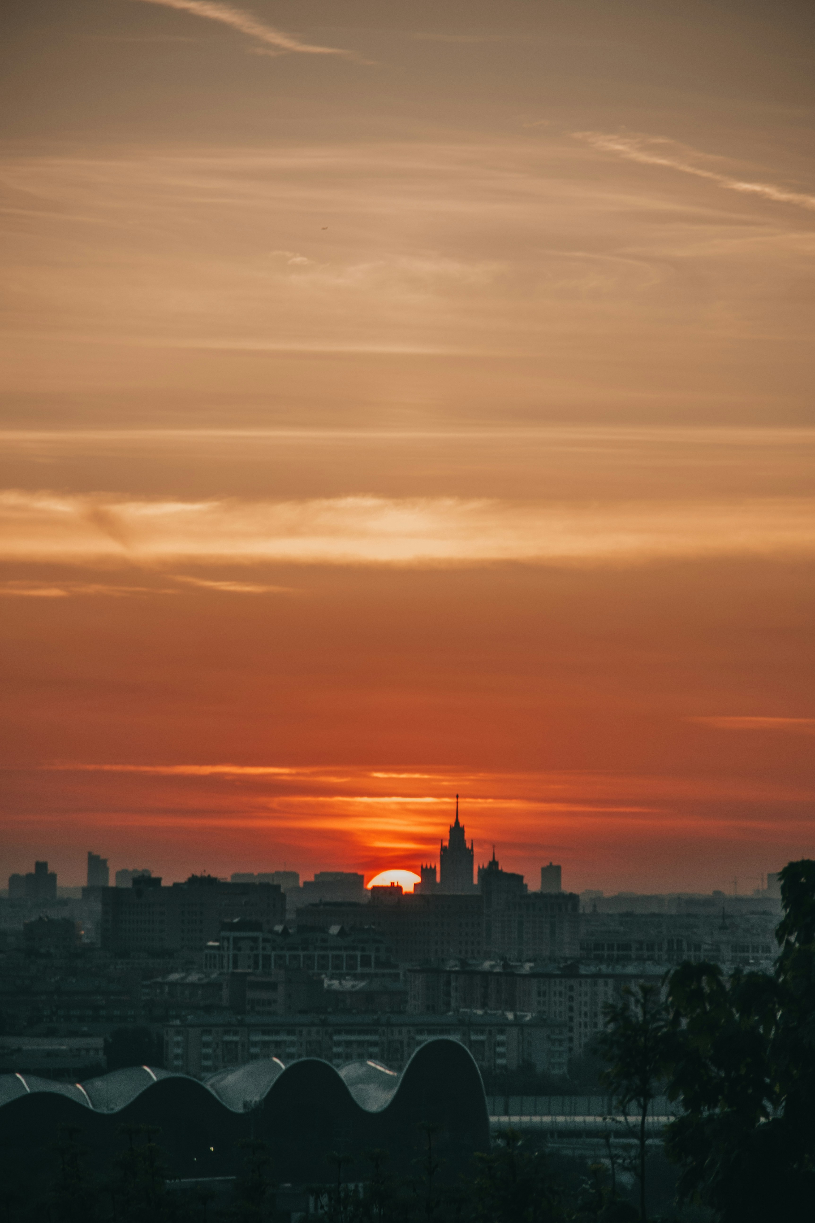 city skyline under orange and gray cloudy sky during sunset