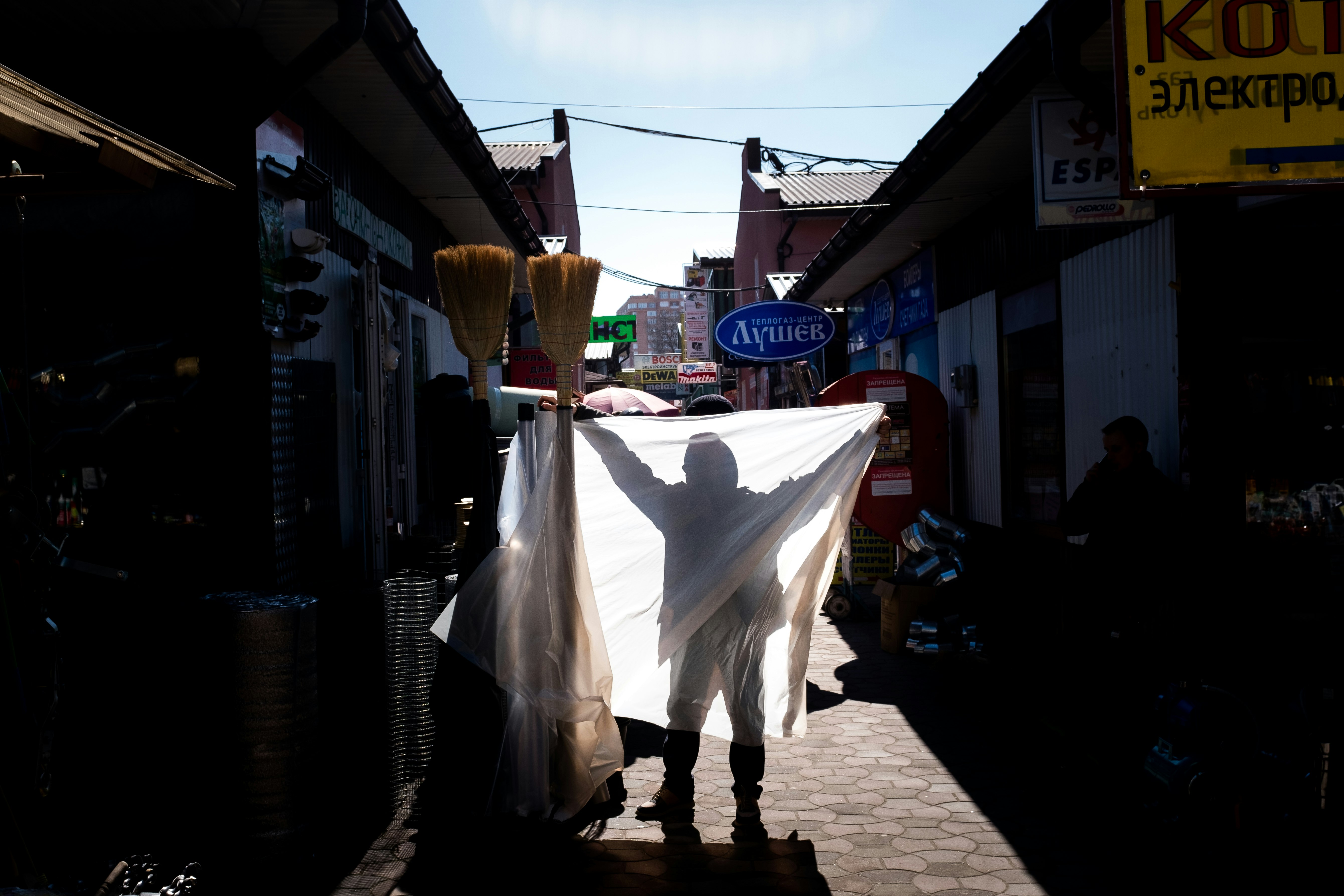 woman in white dress holding white umbrella walking on sidewalk during daytime