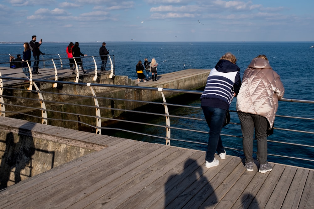 woman in black and white striped long sleeve shirt and blue denim jeans standing on wooden