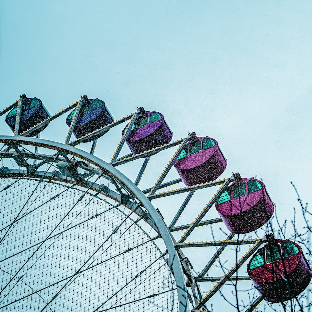 low angle photography of gray metal frame with pink and blue umbrellas