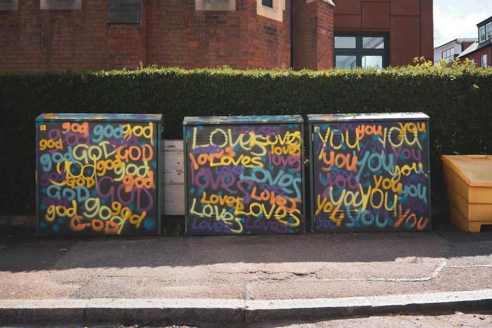 blue and yellow graffiti on black metal fence