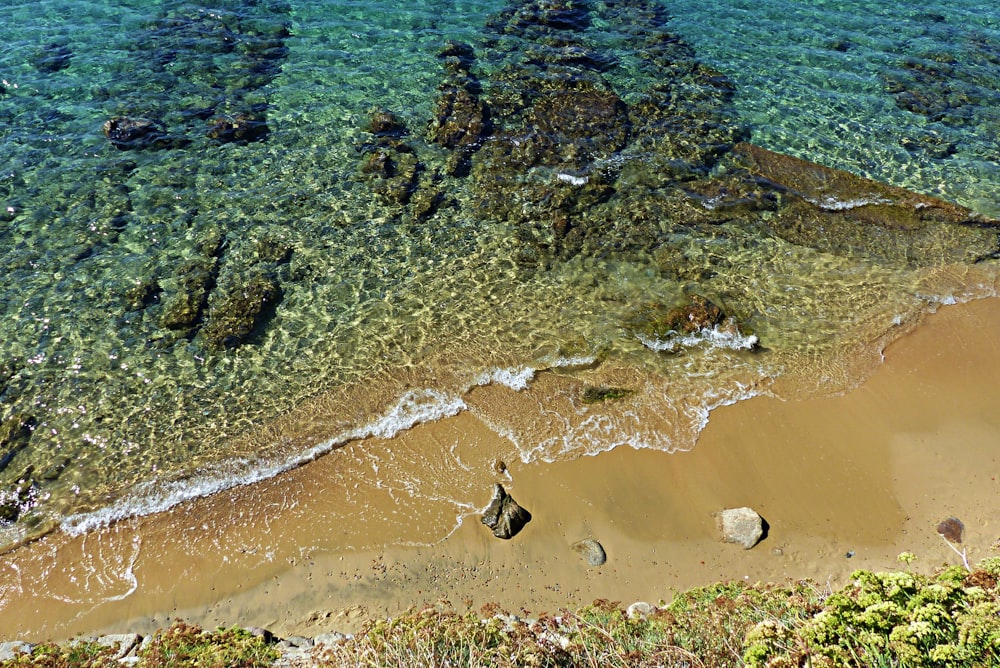 aerial view of sea waves crashing on shore during daytime