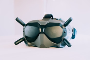 A high-tech virtual reality headset with four antennas protruding from its sides and top. The device has a sleek, matte finish and an ergonomic design for comfortable wear. It appears to have various adjustment mechanisms and buttons, indicating advanced functionality.