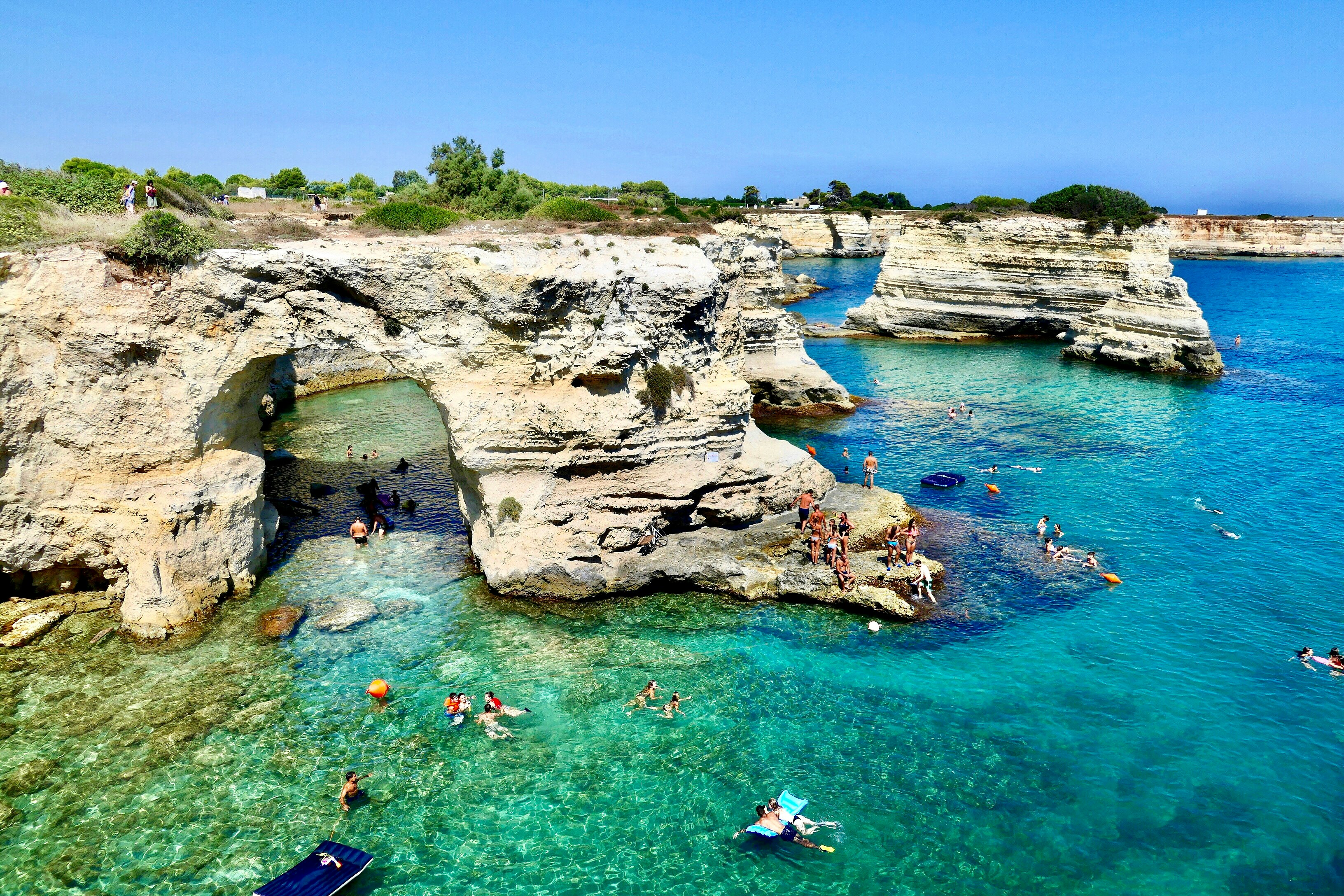 people swimming on sea during daytime