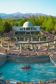 A modern garden featuring artificial grass and a decorative fountain under the Riyadh sun.