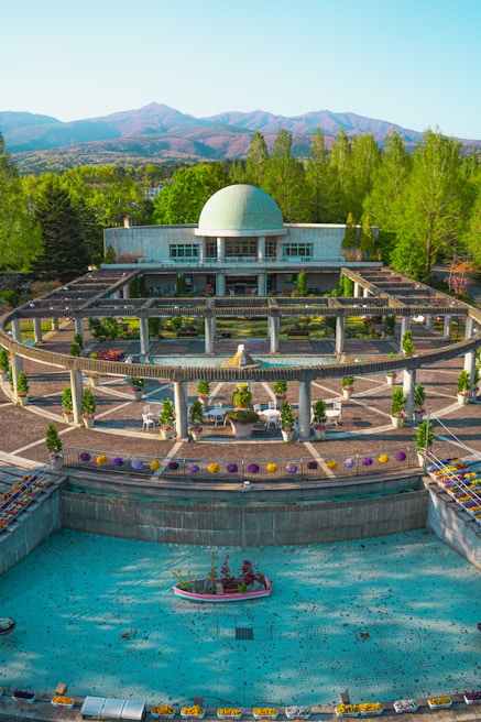 A modern garden featuring artificial grass and a decorative fountain under the Riyadh sun.