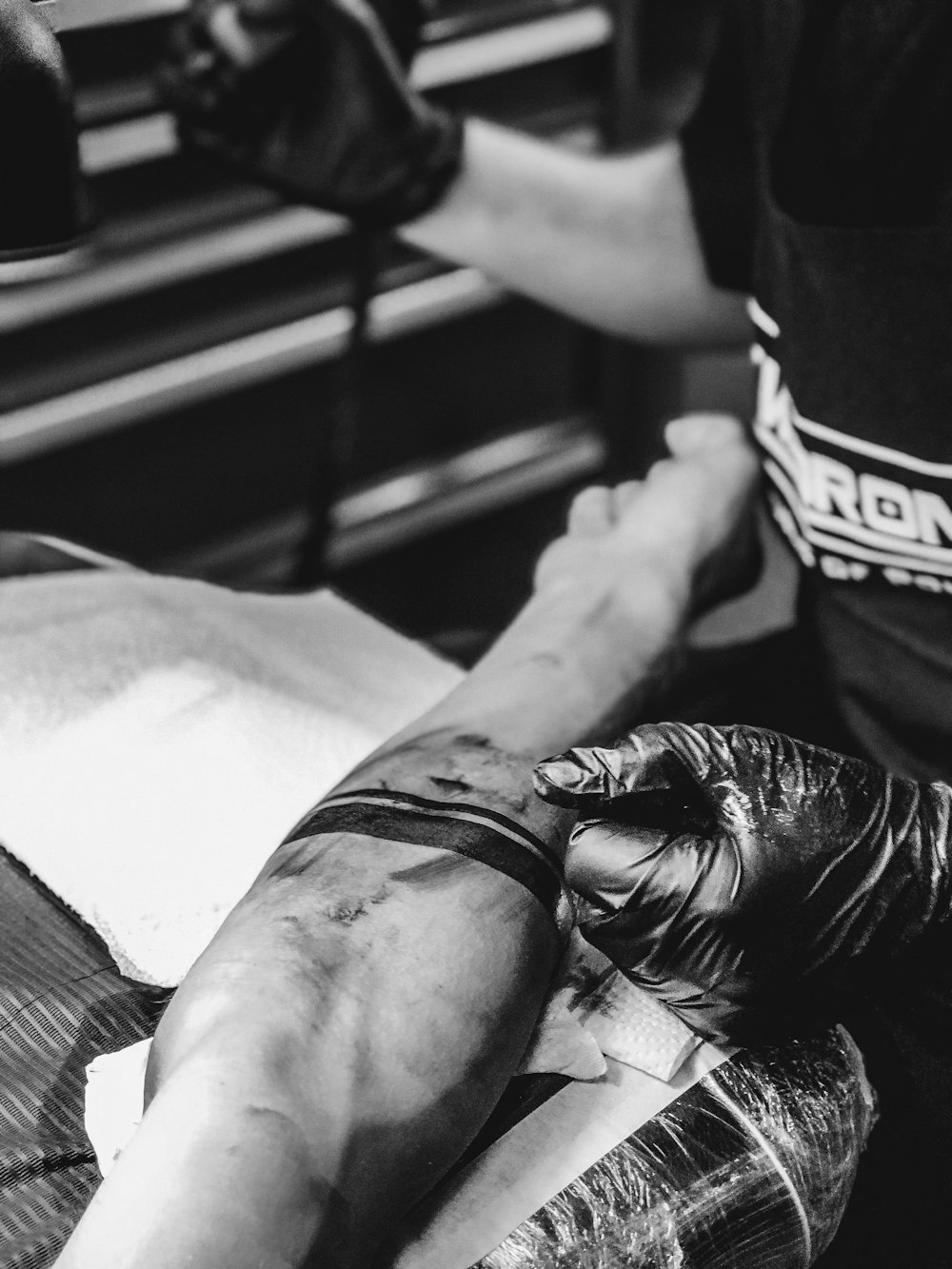 a black and white photo of a person getting a tattoo