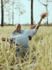 man in white polo shirt and brown pants lying on brown grass field during daytime
