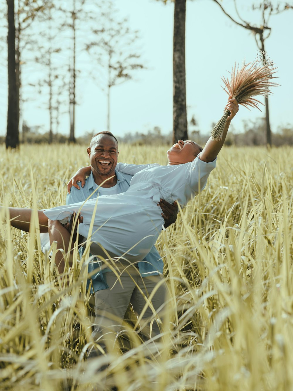 man in white polo shirt and brown pants lying on brown grass field during daytime