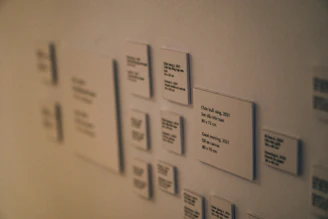 A minimalist display of several metal plaques with QR codes arranged neatly on a black velvet cloth.