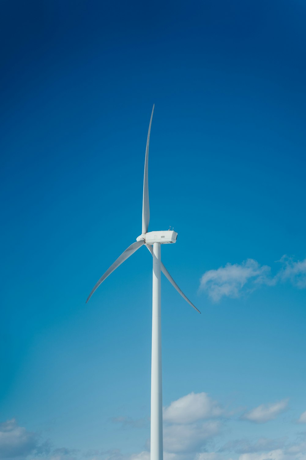 Turbina eólica blanca bajo el cielo azul durante el día