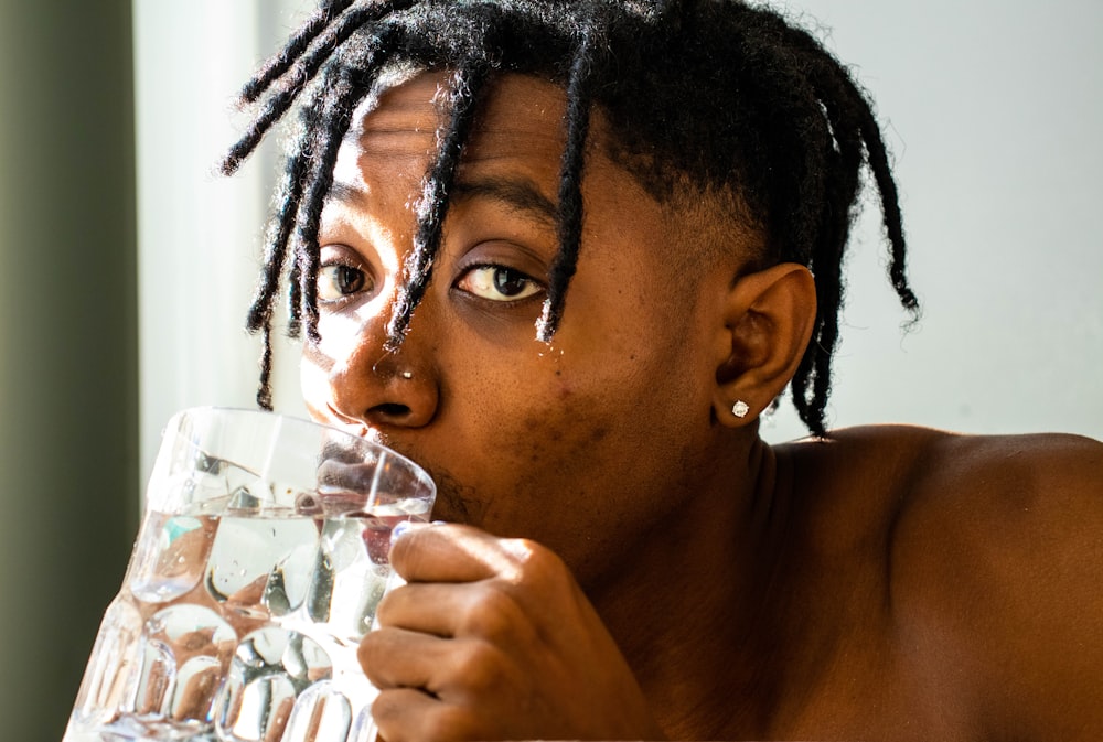 man drinking water from clear drinking glass