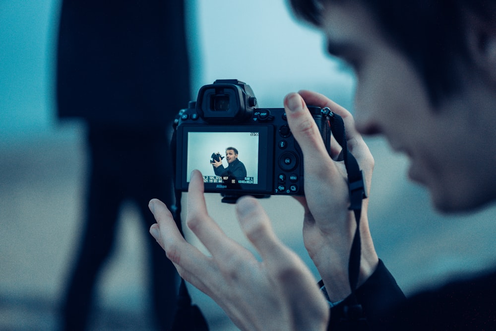 person holding black dslr camera