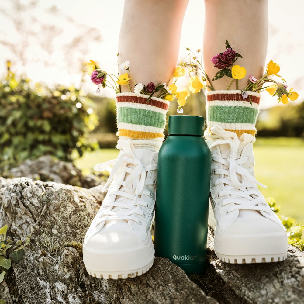 person wearing white and yellow floral rain boots