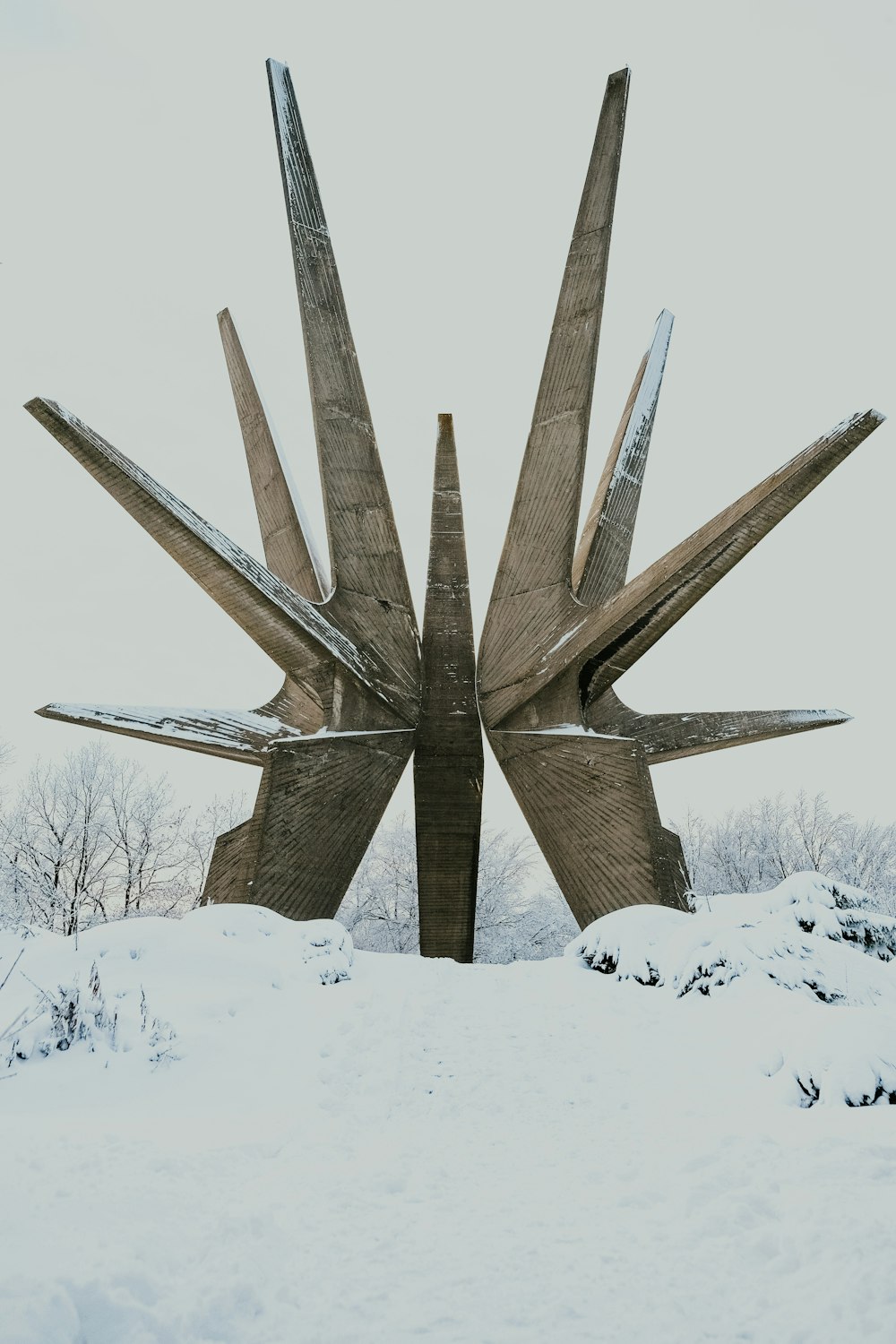 日中の雪に覆われた地面に茶色の木製の十字架