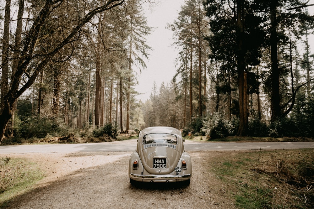 Porsche 911 bianca parcheggiata su strada sterrata vicino agli alberi durante il giorno