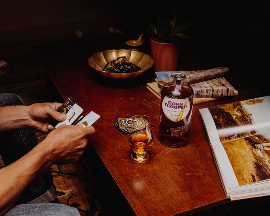 person holding a playing cards on brown wooden table