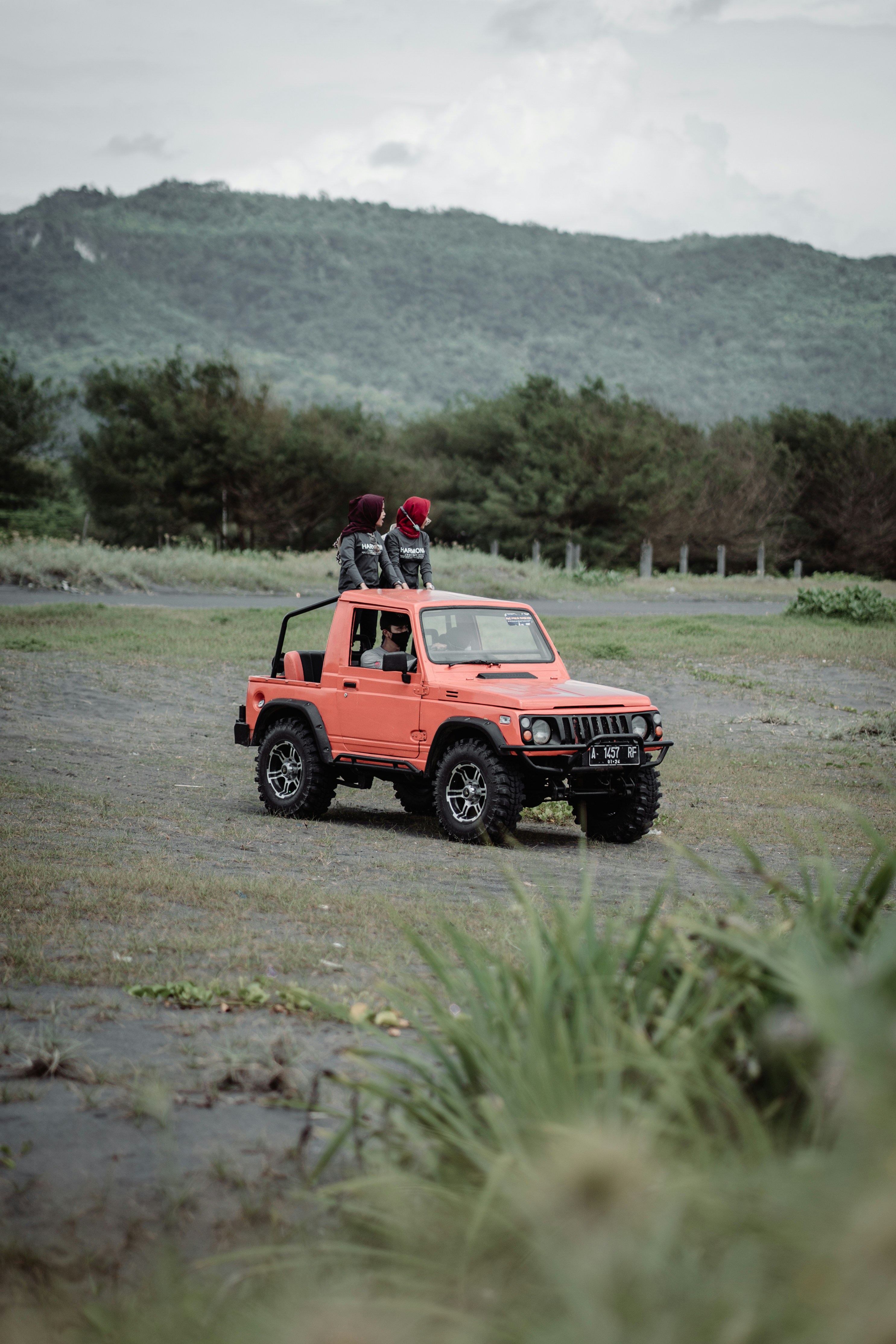 red jeep wrangler on dirt road during daytime