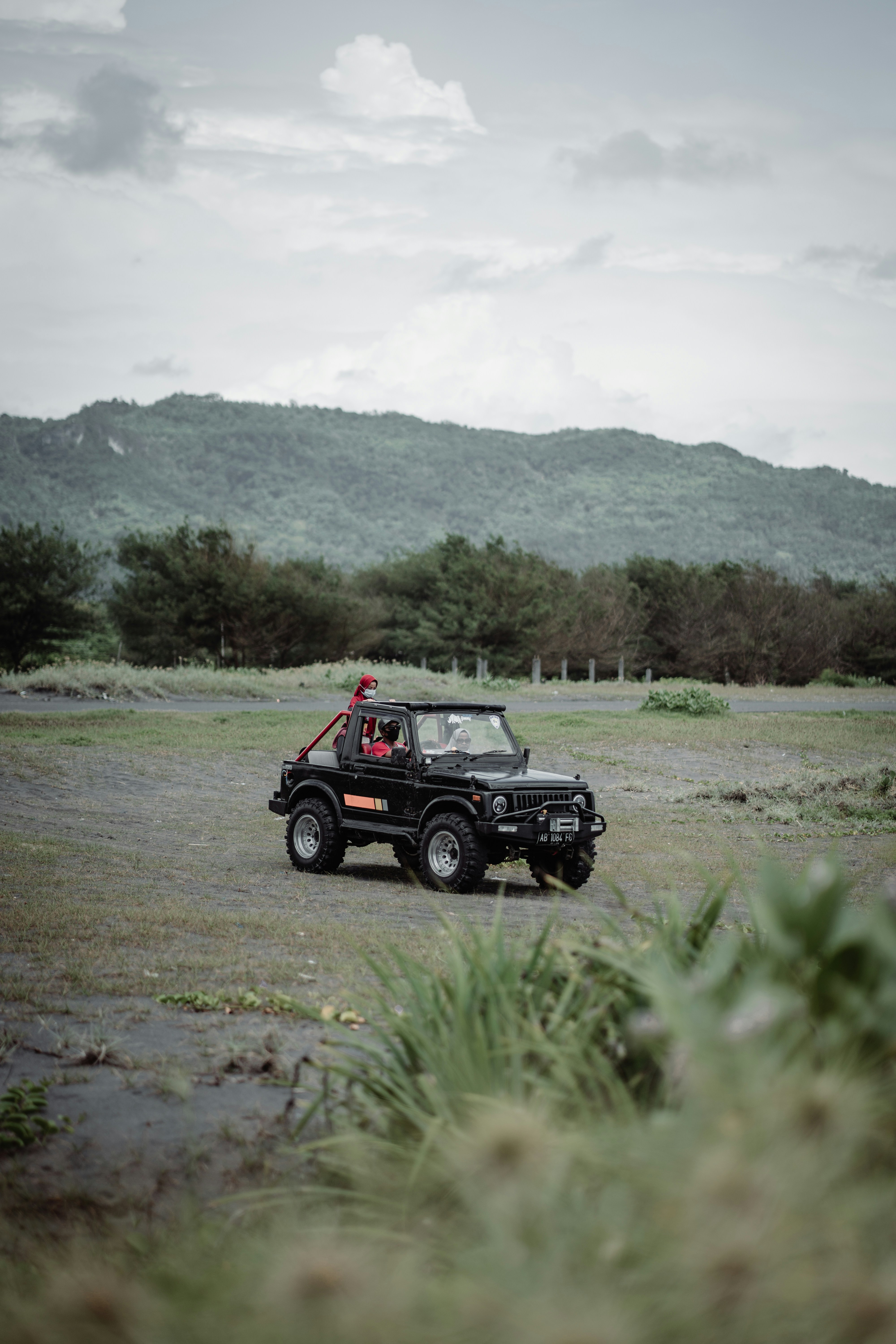 red and black jeep wrangler on dirt road during daytime