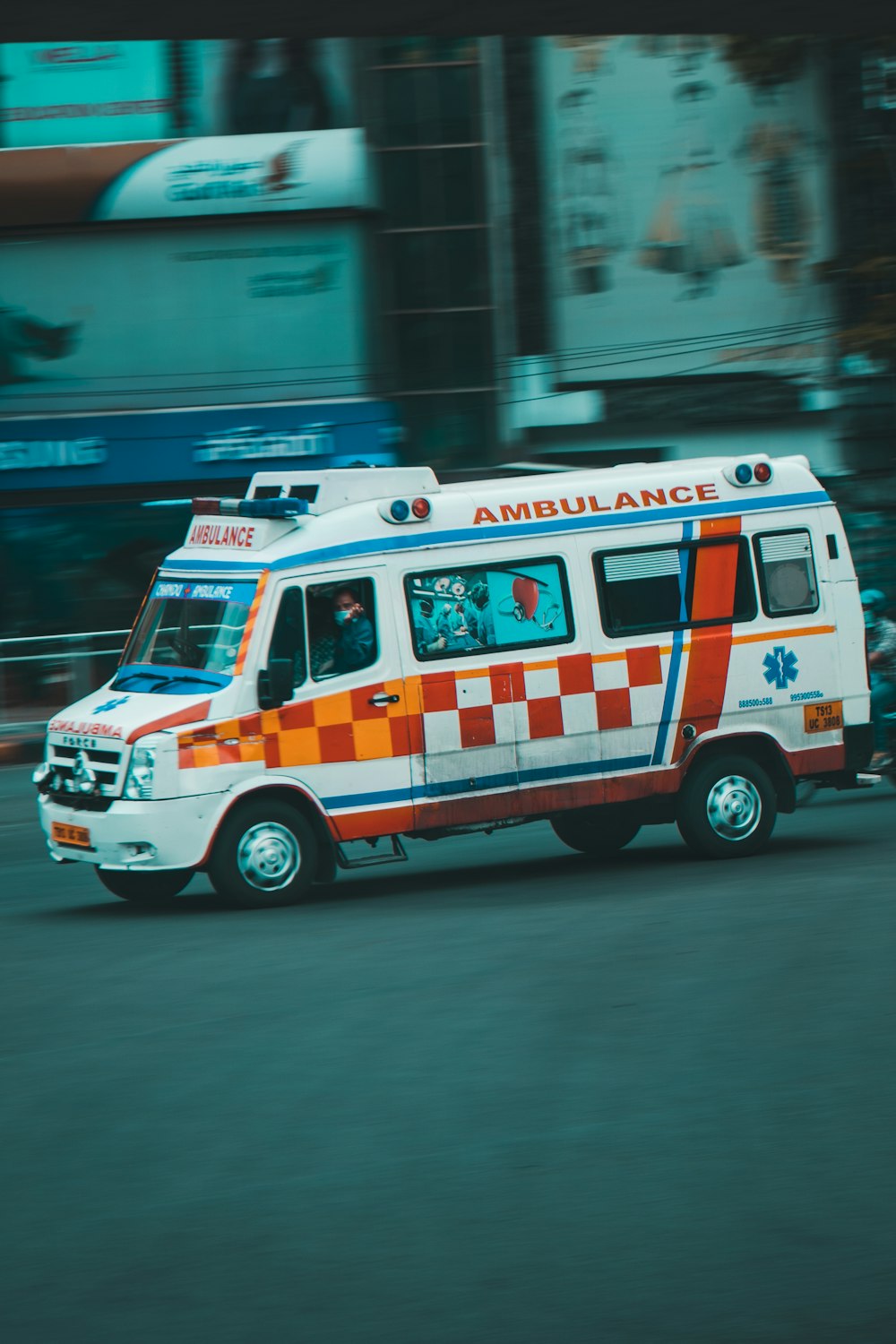 an ambulance driving down a street next to tall buildings