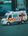 an ambulance driving down a street next to tall buildings
