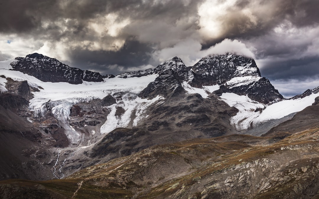 snow covered mountain under cloudy sky during daytime