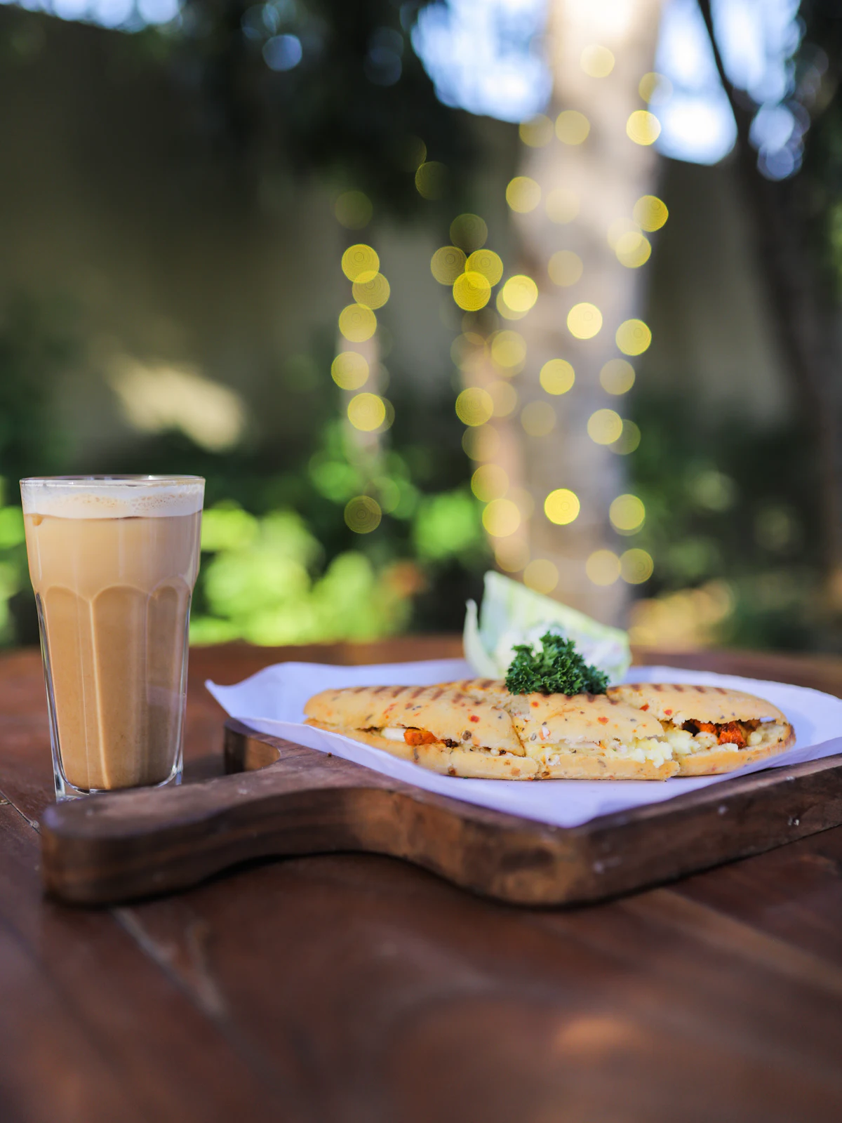 A small cup of dark mushroom coffee on a wooden tray