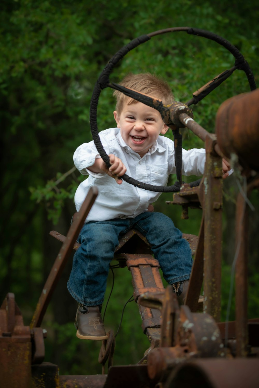 girl in white long sleeve shirt and blue denim jeans sitting on brown wooden wheel during