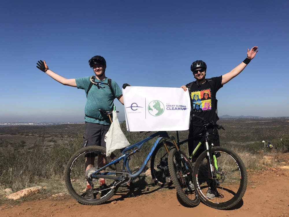 man in green shirt and black pants riding blue mountain bike