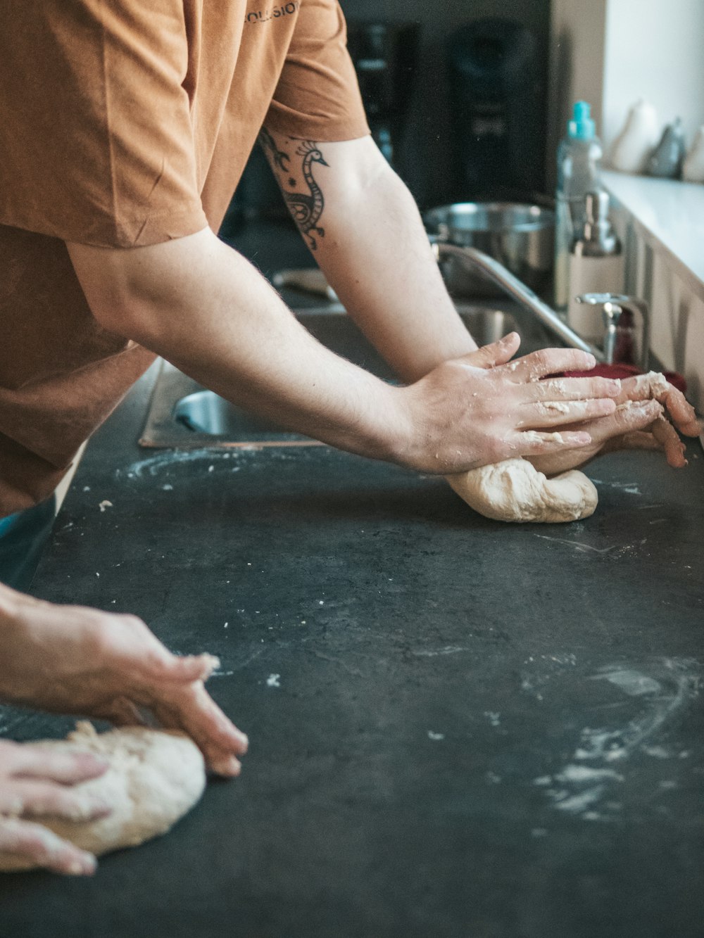person in brown pants and white gloves holding dough