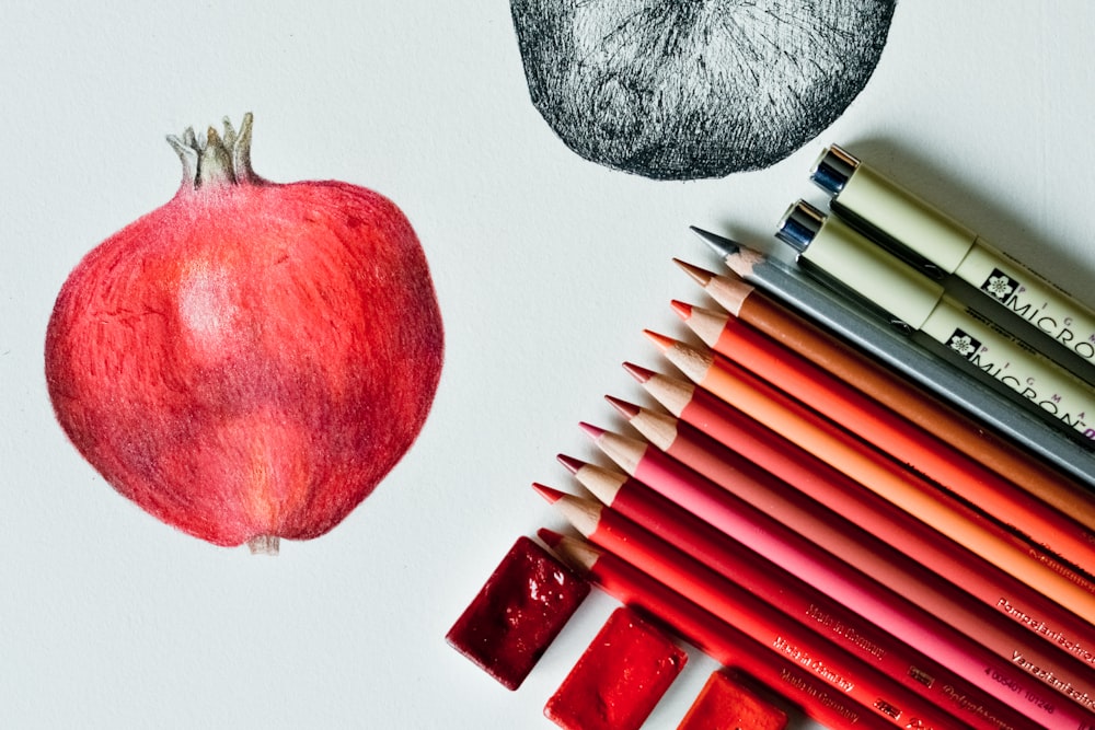 흑백 펜 옆에 빨간 사과 과일