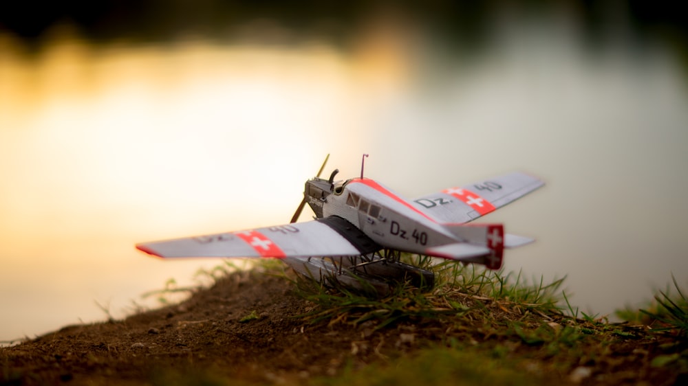 white and red jet plane on brown soil during daytime