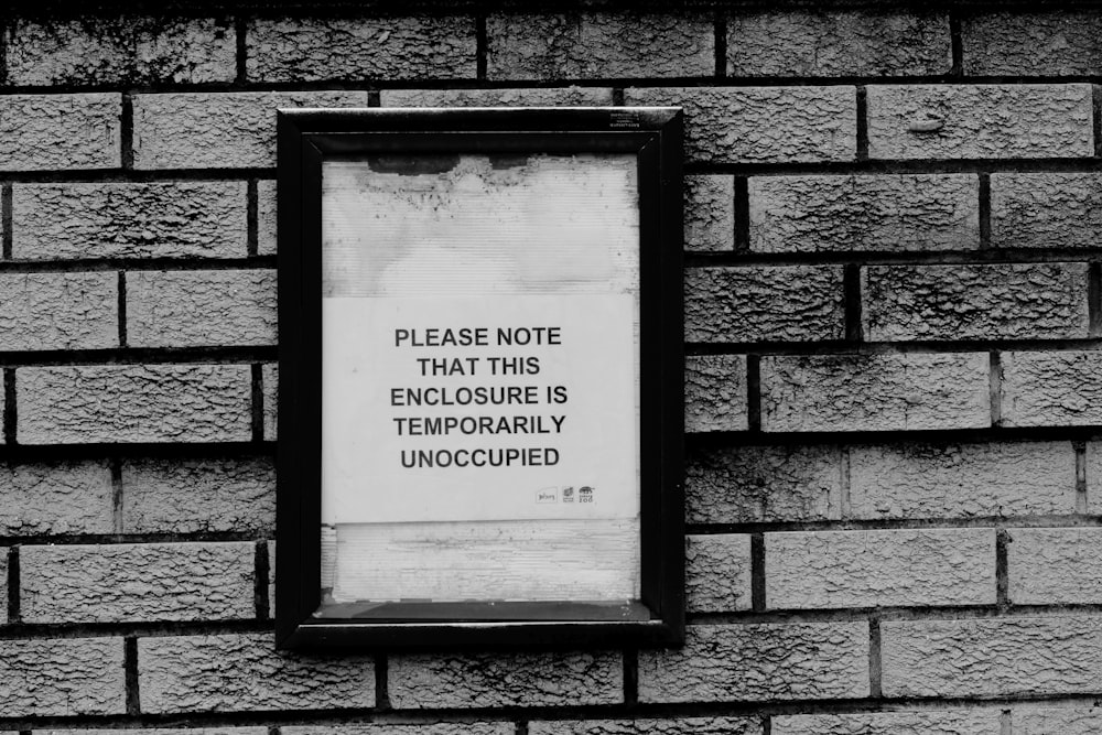 black wooden frame on brown brick wall