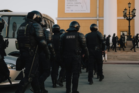 group of police men in black uniform standing on gray concrete floor during daytime