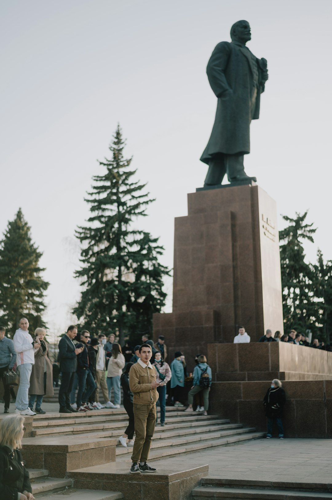 people standing near statue of man