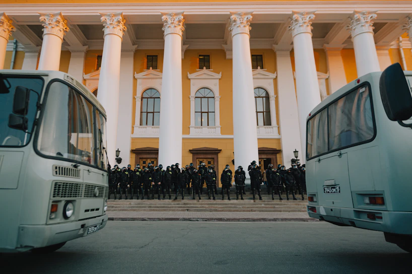 A group of professional security personnel standing alert outside a commercial building.