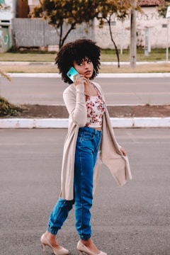 A young adult using a smartphone while walking outdoors.