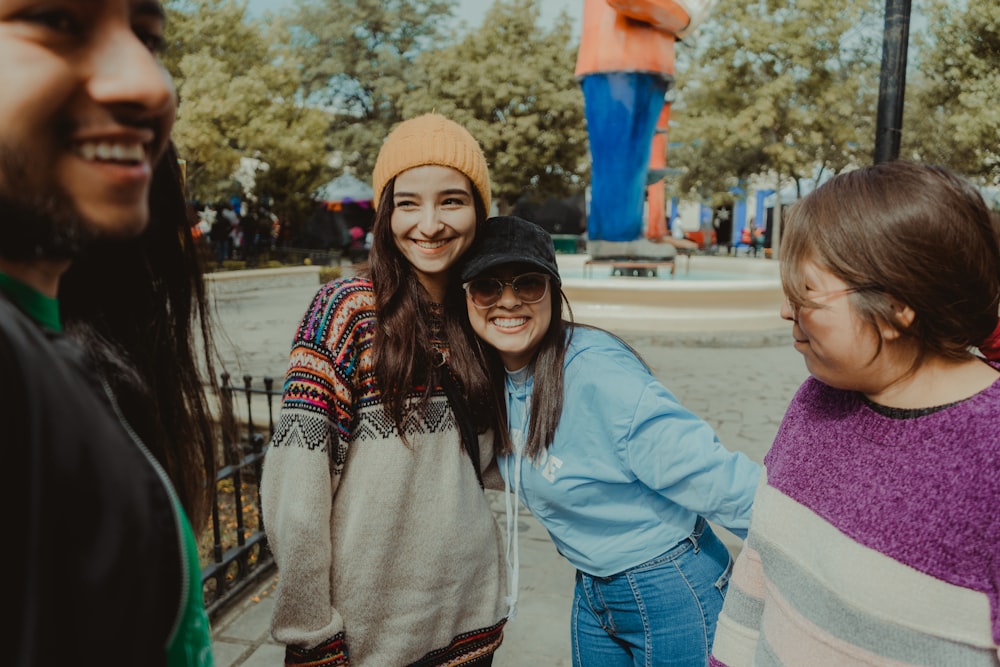 Femme en pull gris souriant à côté d’une fille en veste bleue