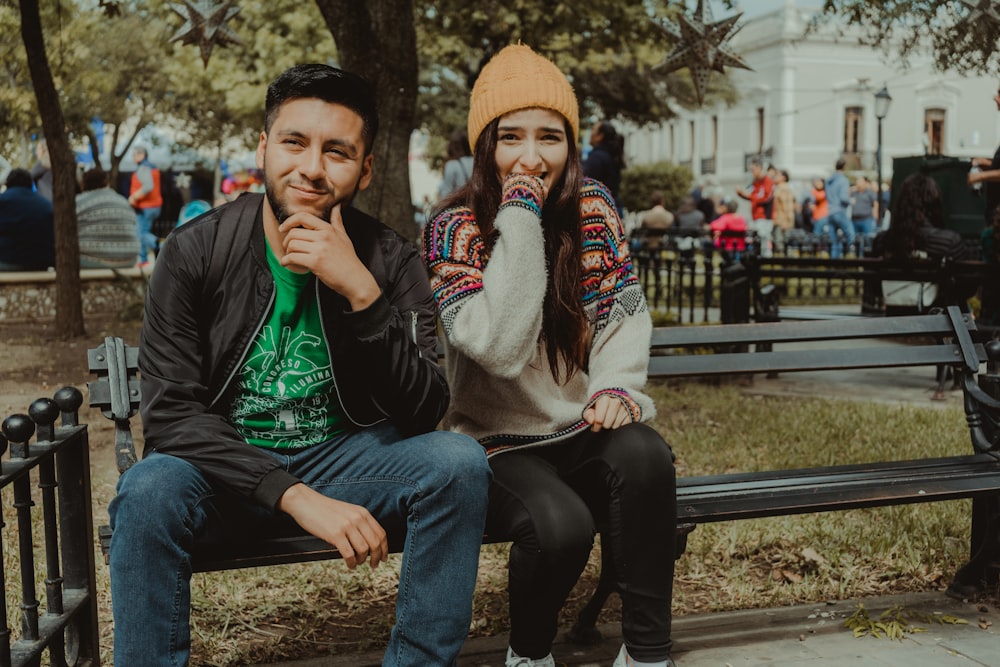 man in gray hoodie and blue denim jeans sitting on bench