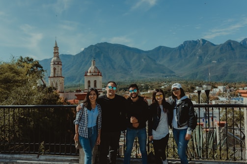 A group of happy travelers enjoying a scenic mountain view during a guided tour.