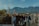 Smiling travelers enjoying a scenic mountain view during a group tour.