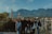 Smiling travelers enjoying a scenic mountain view during a group tour.