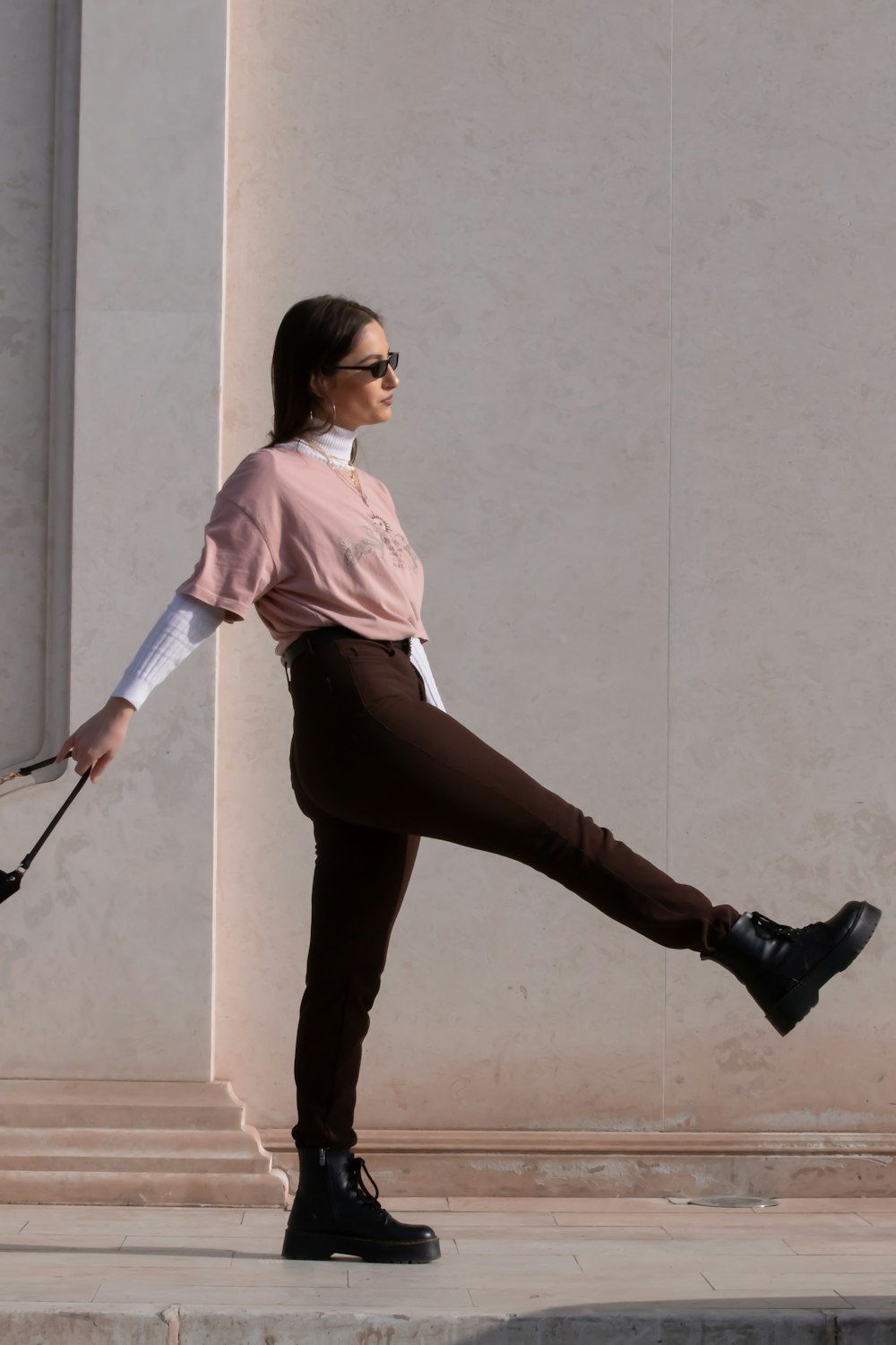 woman in pink shirt and black pants holding walking stick