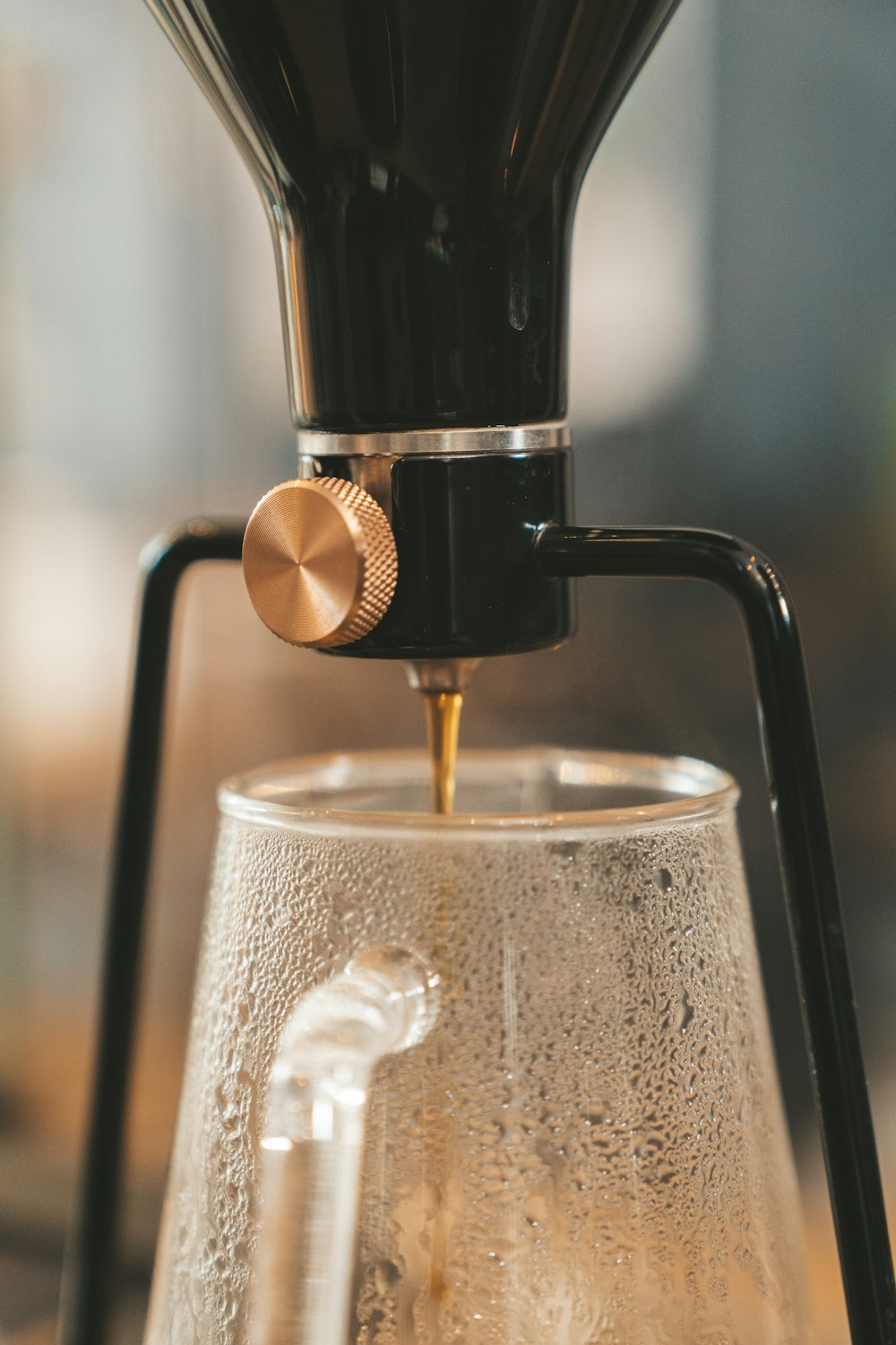 black and white coffee maker pouring water on clear glass cup